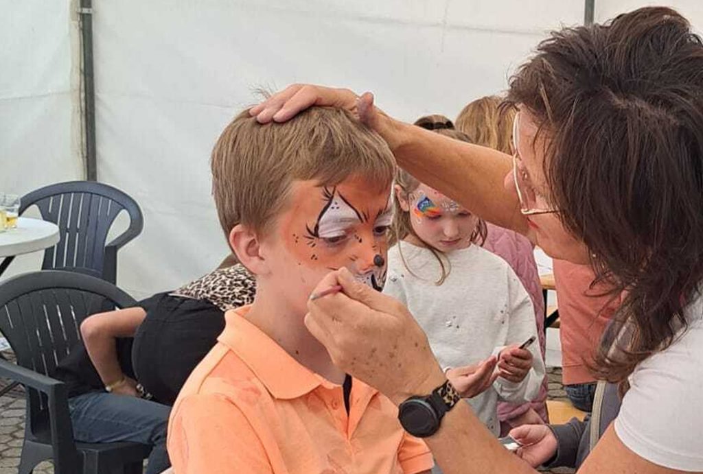 Jongen die wordt geschminkt als tijger