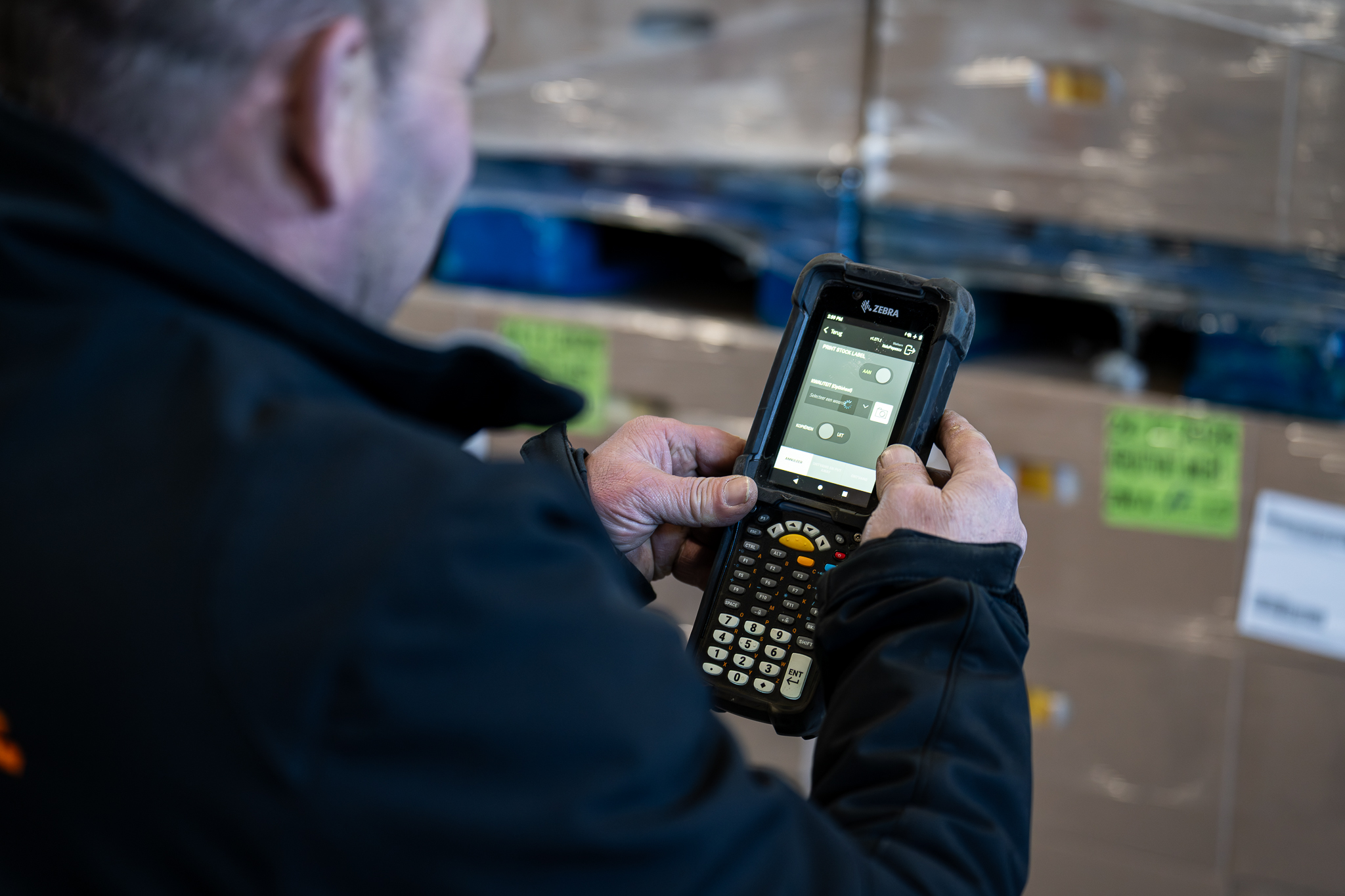 Medewerker gebruikt scanner bij pallets in het Vos Transport warehouse