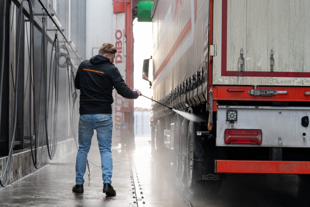 Vos Transport medewerker reinigt trailer met hogedrukspuit