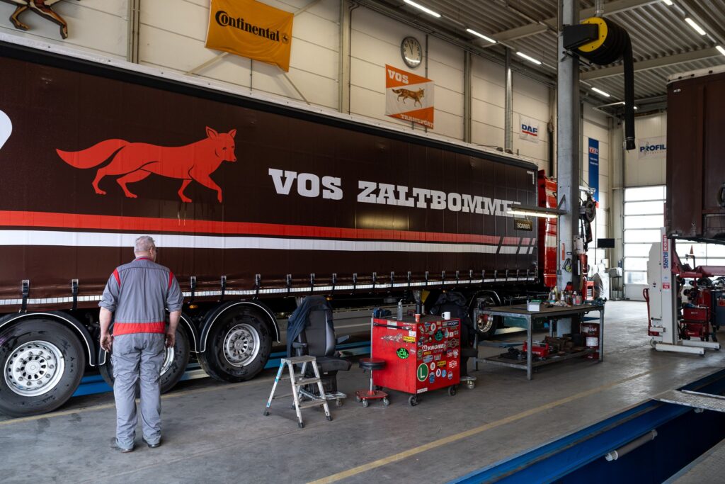 Monteur werkt aan vrachtwagen in de Vos Transport werkplaats