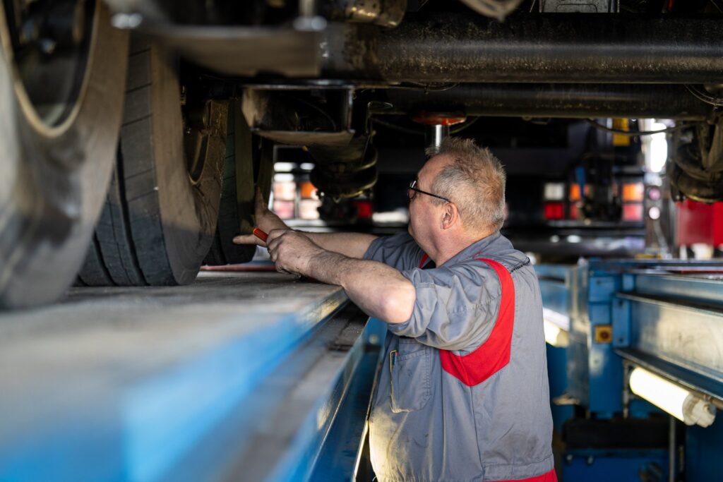 Monteur inspecteert truckonderstel van onderaf op de hefbrug